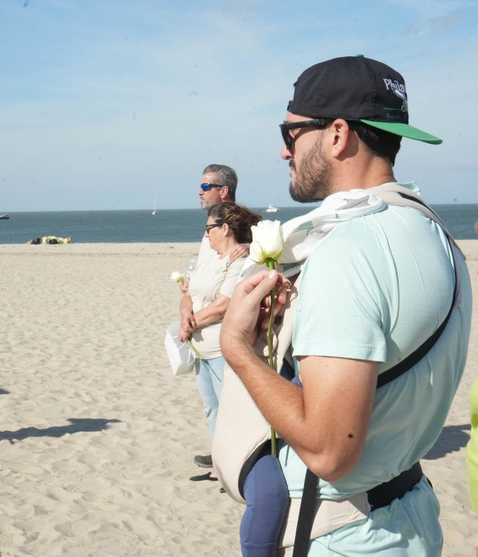 Lyle Delarosa holds his baby and a white rose during the memorial service. He is there to honor his nephew, Waylon Edgar, who died only a week after he was born. Also shown are Rich and Stephanie Steele.